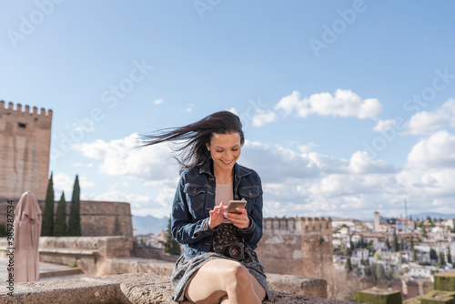 Принти на полотні Young woman looking smartphone in Granada, Spain.