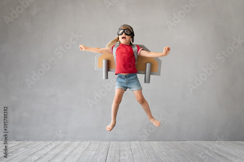 Fototapeta Naklejka Na Ścianę i Meble -  Child with jetpack jumping against grey concrete background