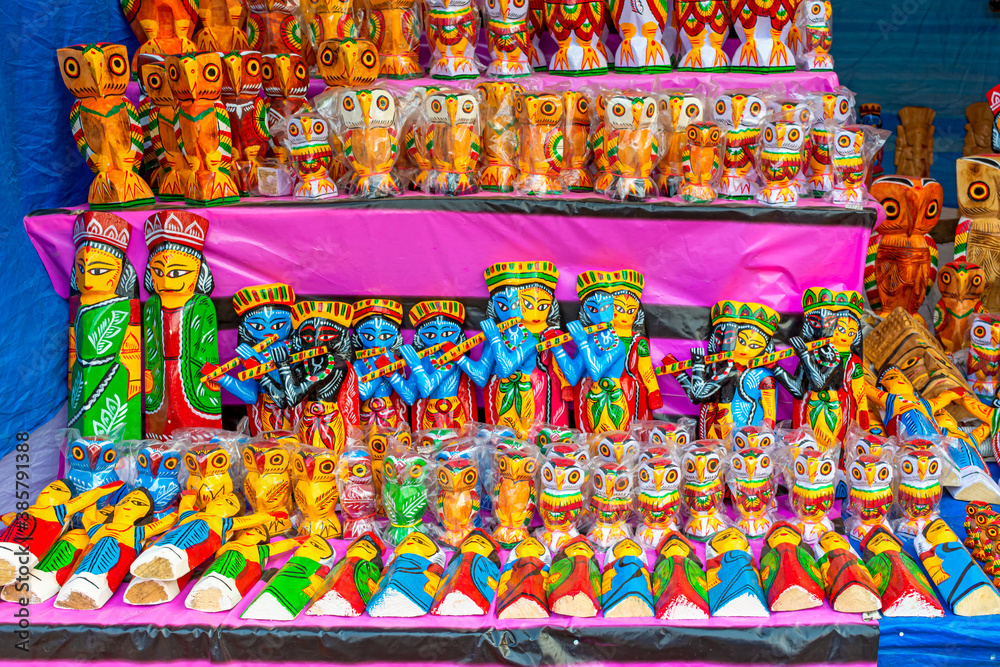 A collection of colorful handmade traditional wooden owl sculpture and toys are displayed for selling in handicraft fair.