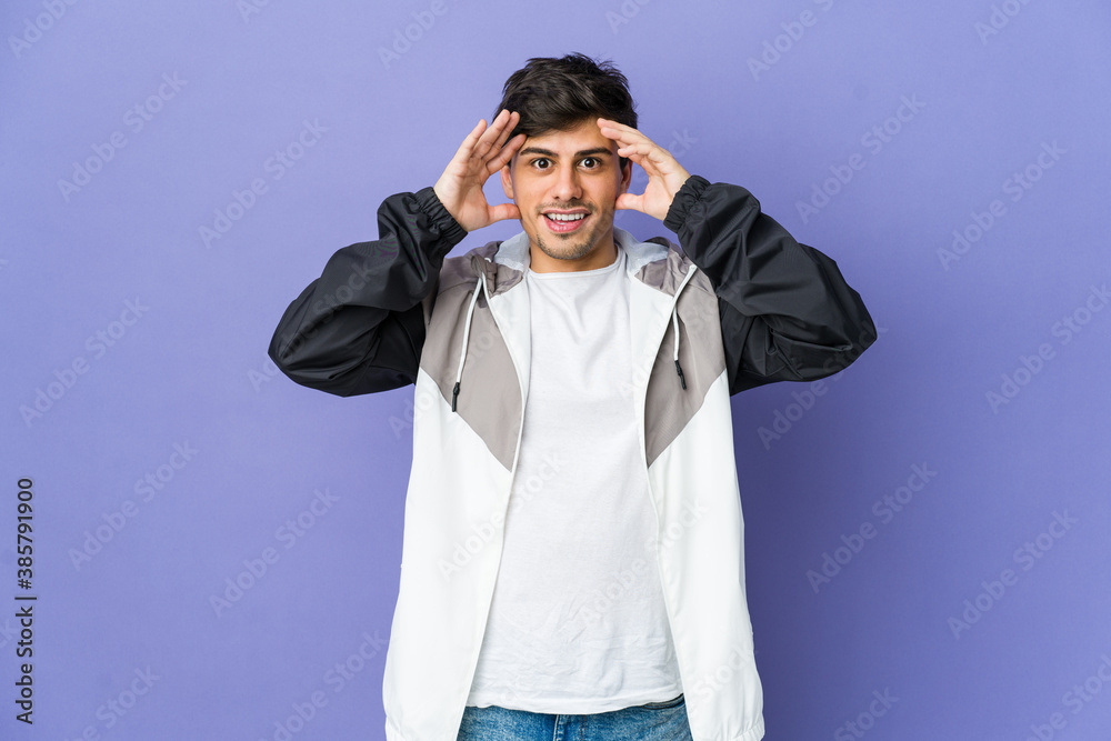 Young cool man receiving a pleasant surprise, excited and raising hands. Young cool man receiving a pleasant surprise, excited and raising hands.