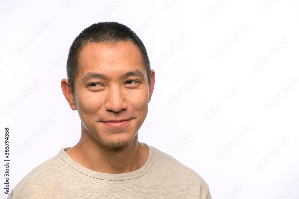 Portrait of young man of Asian descent with smirk looking off camera Portrait of young man of Asian descent with smirk looking off camera