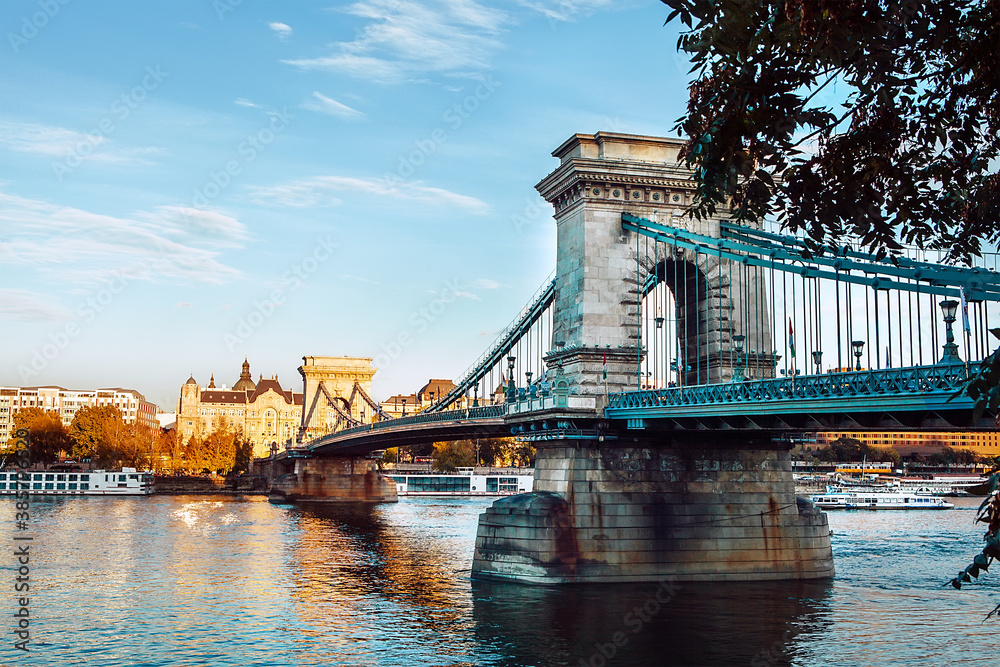Obraz premium Chain Bridge in Budapest also known as Szechenyi lanchid connecting the Buda and Pest - the main Hungarian capital's parts separated by Danube river. Old Europe traveling concept photo.