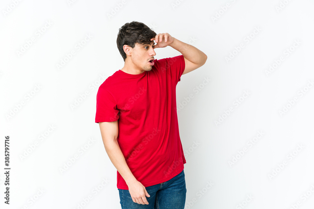 Young cool man looking far away keeping hand on forehead. Young cool man looking far away keeping hand on forehead.