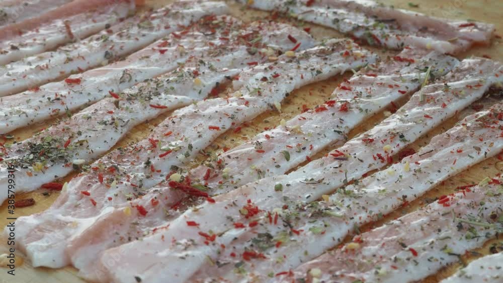 fresh bacon sprinkled with spices. pork bacon on a wooden Board.