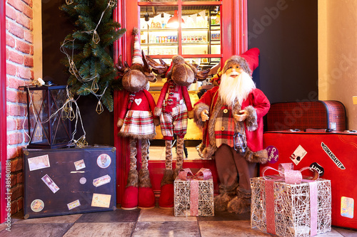 IZMAIL, UKRAINE - December 25, 2019: Decorated interior of cozy vintage cafe or restaurant at christmas and new year holidays. Interior with Santa claus, reindeer, phone booth, suitcases photo