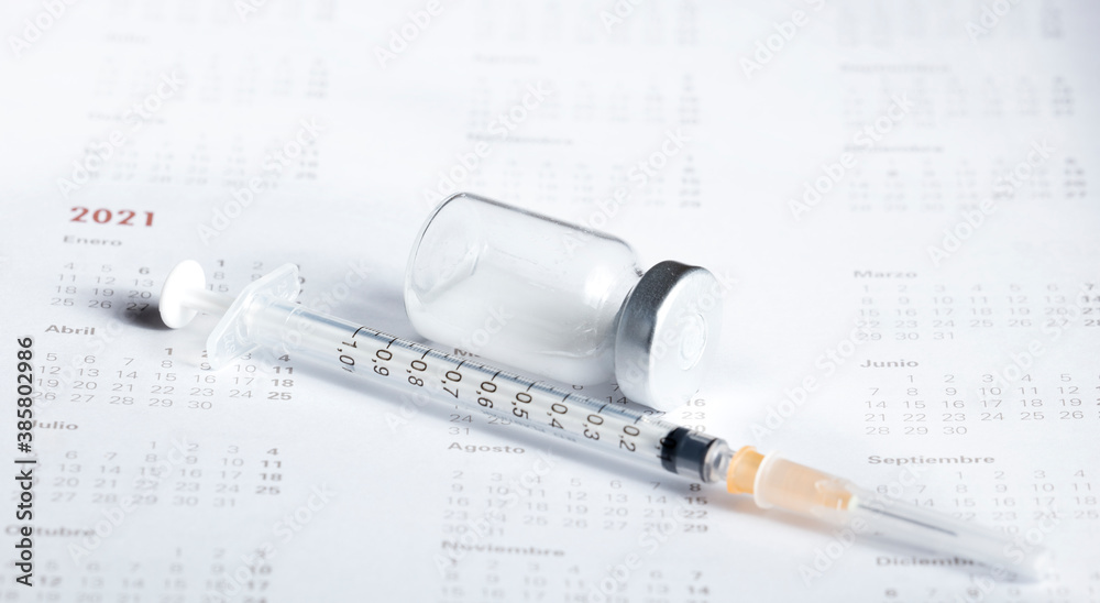 Medical concept. In the calendar, syringe with container of epidemic vaccine. Medical concept. In the calendar, syringe with container of epidemic vaccine.
