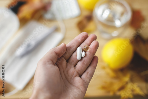 Boost immune system, coronavirus treatment. Hand with vitamin D, vitamin C and zinc pills