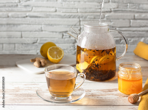 Tea with lemon, ginger and honey on white wooden table. Alternative medicine.