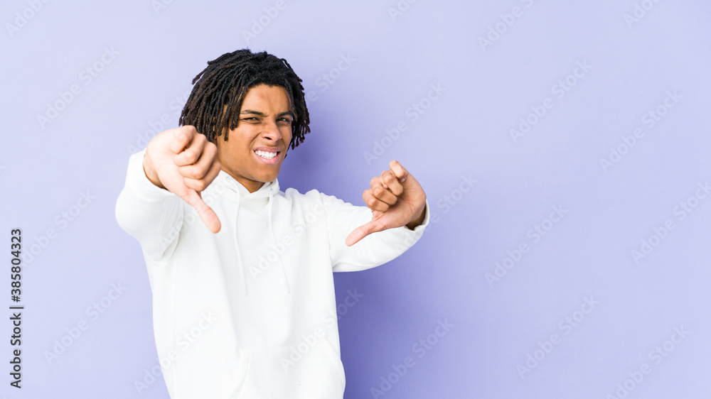 Young african american rasta man showing thumb down and expressing dislike. Young african american rasta man showing thumb down and expressing dislike.