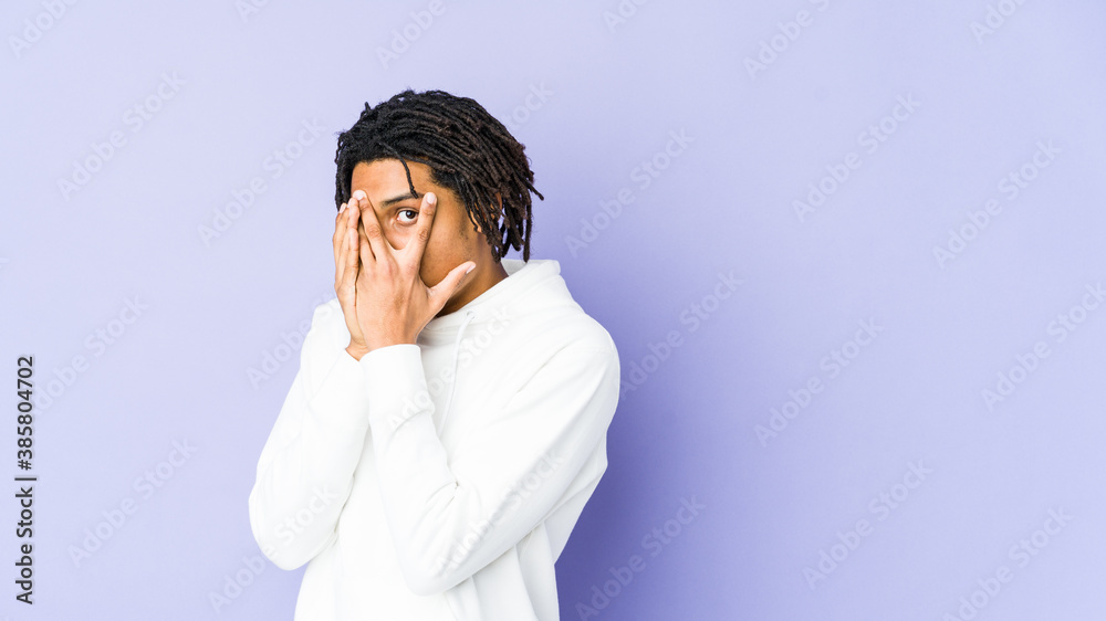 Young african american rasta man blink through fingers frightened and nervous. Young african american rasta man blink through fingers frightened and nervous.