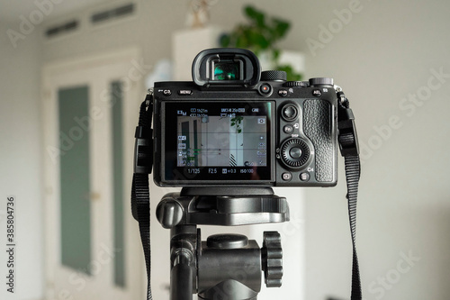 Close-up of digital camera on tripod in living room at home