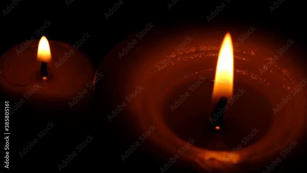 Two stearin candles are burning on a black background high resolution video clip Two stearin candles are burning on a black background high resolution video clip