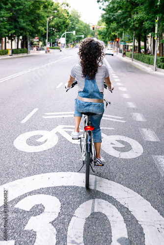 Woman riding electric bicycle on street in city