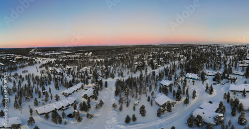 Finland, Lapland, Saariselka, Aerial view ofÔøΩsnow-coveredÔøΩmountain village at dusk photo