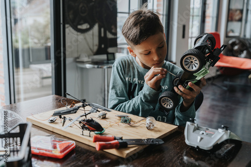 Wallpaper Mural Boy assembling on remote-controlled toy car with screwdriver Torontodigital.ca
