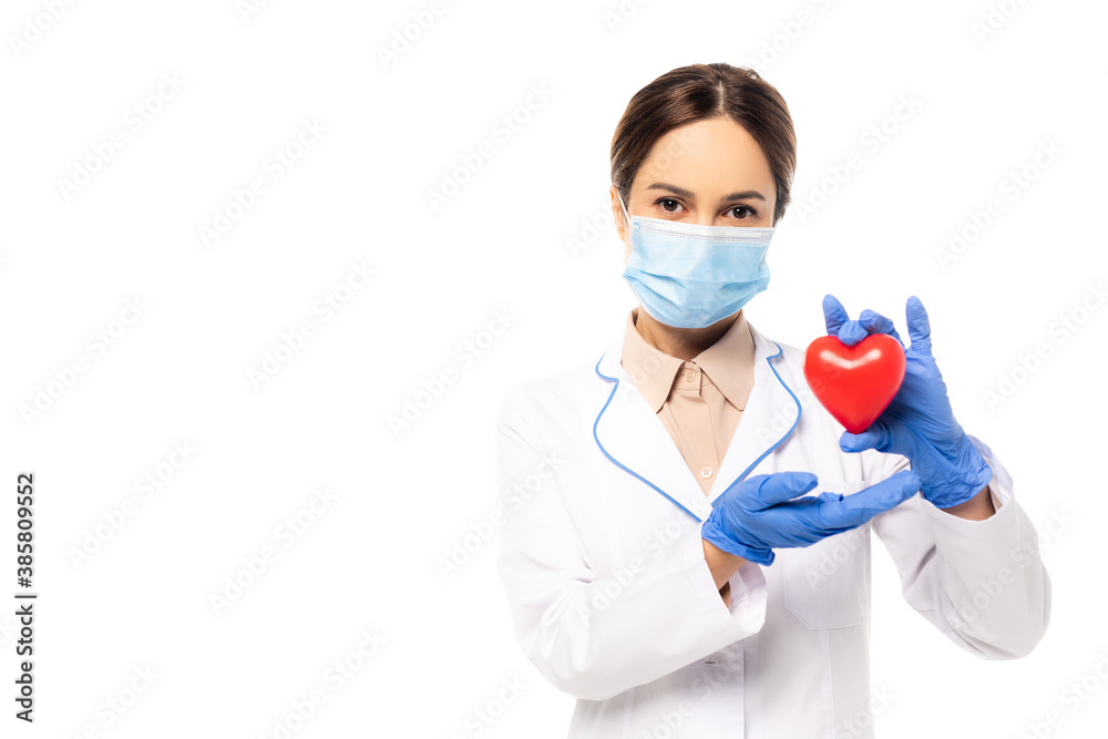 Doctor in medical mask and latex gloves holding heart isolated on white Doctor in medical mask and latex gloves holding heart isolated on white