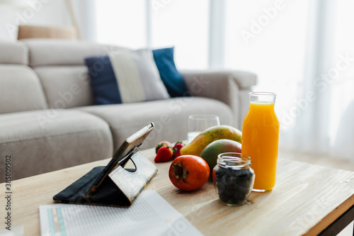 Fruit and drink kept with digital tablet on table at home photo