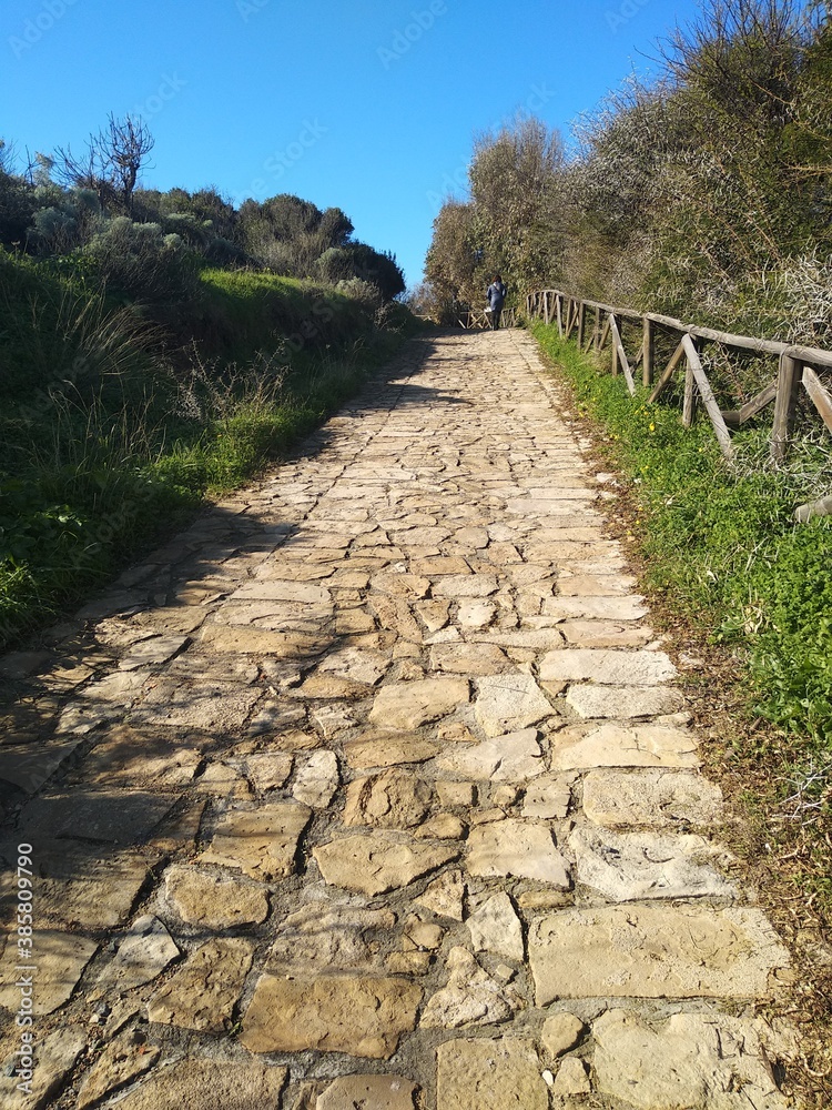 Stone pathway up the hill leading to Chia tower in Sardinia, Italy