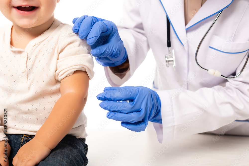 Cropped view of pediatrician in latex gloves touching toddler boy isolated on white Cropped view of pediatrician in latex gloves touching toddler boy isolated on white