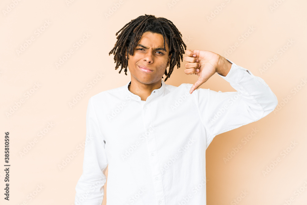 Young african american rasta man showing thumb down, disappointment concept. Young african american rasta man showing thumb down, disappointment concept.