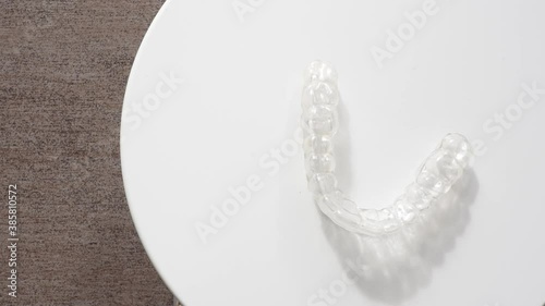 Invisalign removable and invisible retainer on white surface, modern tooth transparent aligners or braces to straighten teeth in cosmetic dentistry and orthodontics