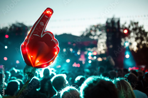 Large foam hand over crowd of people having fun during music festival photo