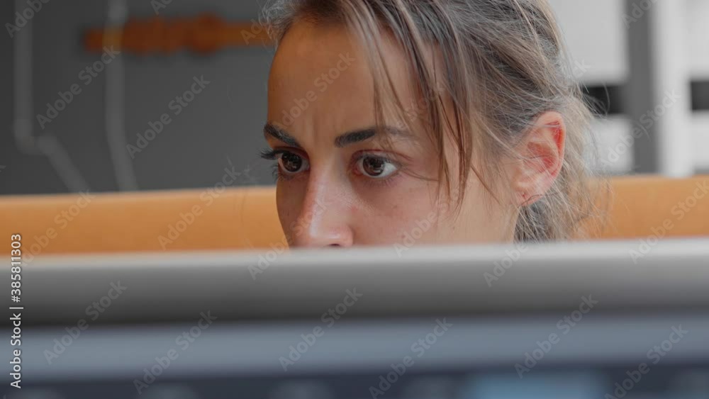 closeup eyes of focused and pensive, worried female scientist or laboratory assistant looks attentively and intently at monitor screen. medic thinking and solving problem of covid-19 vaccine