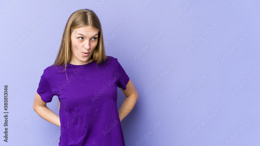 Young blonde woman isolated on purple background being shocked because of something she has seen. Young blonde woman isolated on purple background being shocked because of something she has seen.