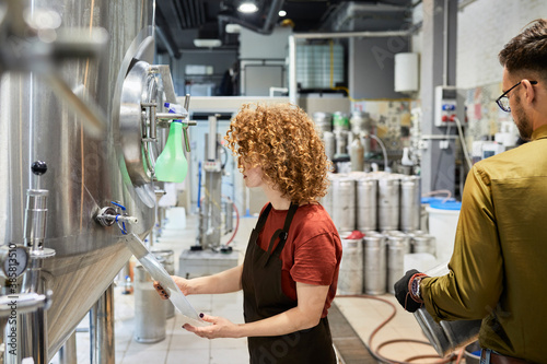 Man and woman working in craft brewery photo