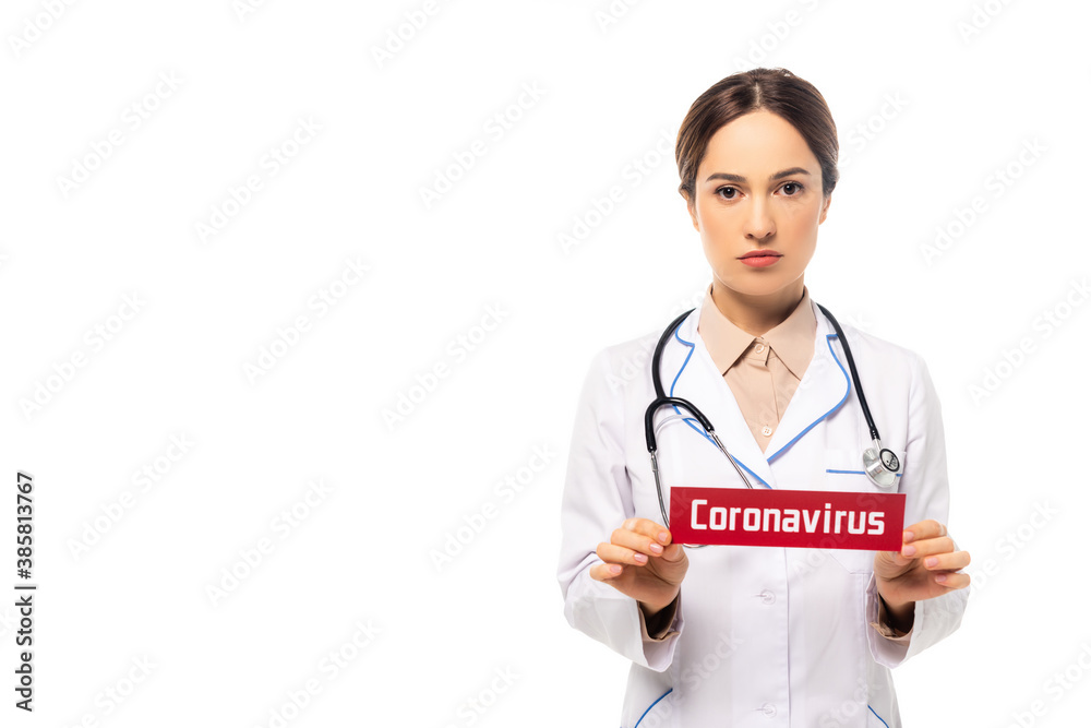 Doctor in white coat holding card with coronavirus lettering isolated on white Doctor in white coat holding card with coronavirus lettering isolated on white