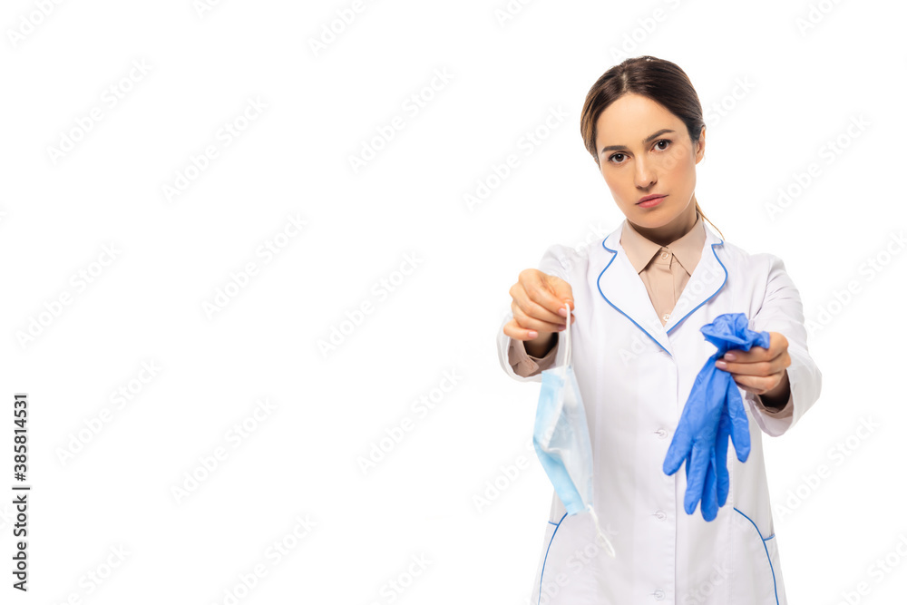Doctor in white coat showing medial mask and latex gloves isolated on white Doctor in white coat showing medial mask and latex gloves isolated on white