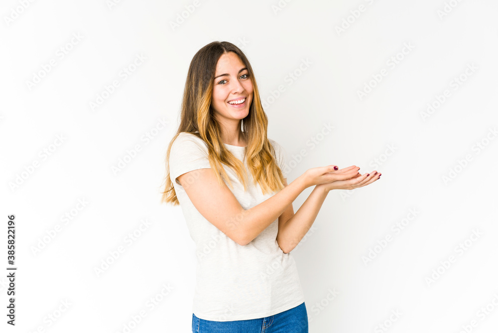Young caucasian woman isolated on white background holding a copy space on a palm. Young caucasian woman isolated on white background holding a copy space on a palm.