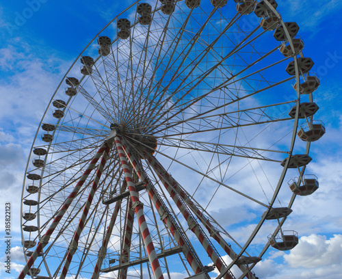 Low angle view of a ferris wheel against a blue sky