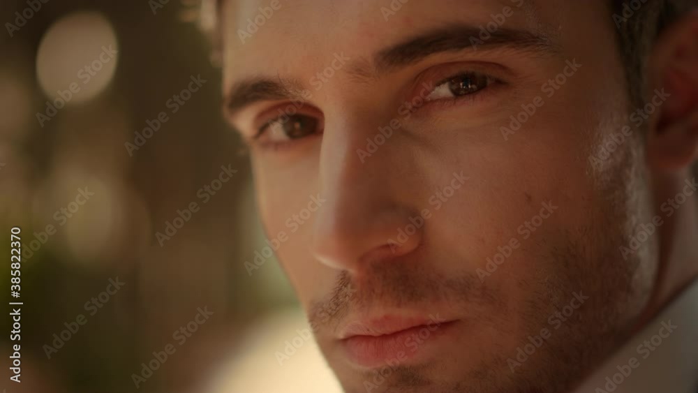Hot guy posing in garden. Romantic male person staring at lens outdoors Hot guy posing in garden. Romantic male person staring at lens outdoors