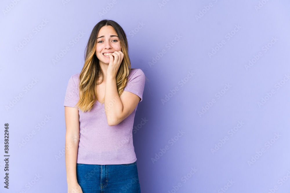 Young caucasian woman isolated on purple background biting fingernails, nervous and very anxious. Young caucasian woman isolated on purple background biting fingernails, nervous and very anxious.