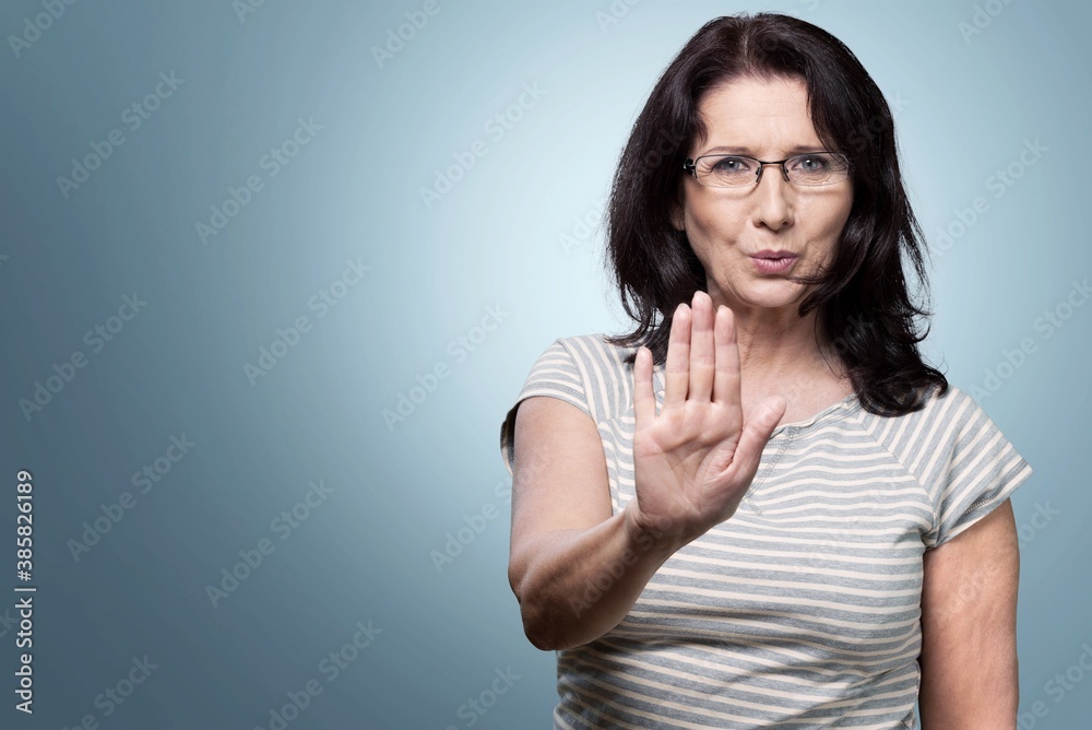 Middle-aged woman showing stop sign Middle-aged woman showing stop sign