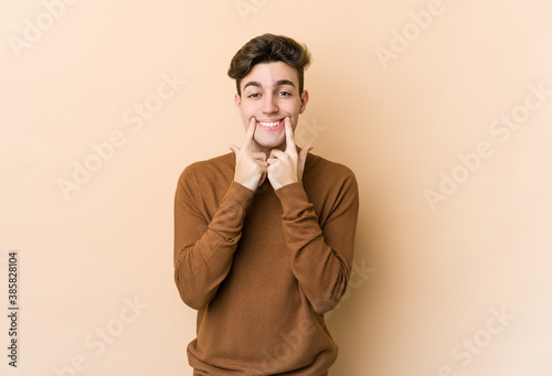 Young caucasian man isolated on beige background doubting between two options.