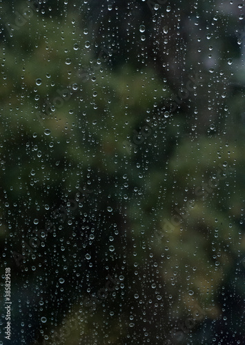 raindrops on window glass. summer background. selective focus. © Arina