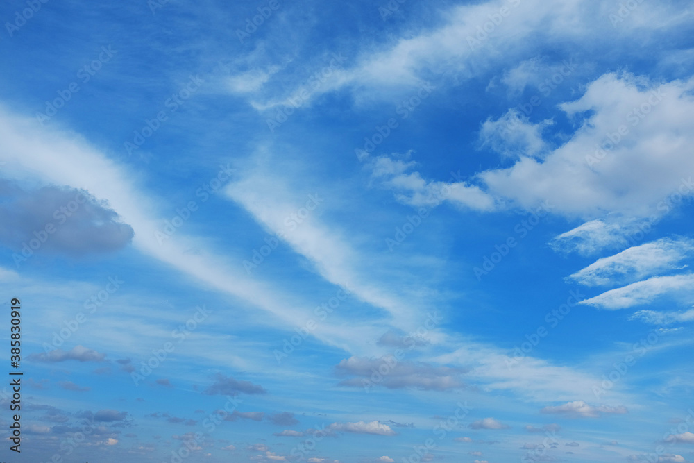 White cirrus clouds on a background of dark blue sky. The cloud resembles a flying angel. White cirrus clouds on a background of dark blue sky. The cloud resembles a flying angel.