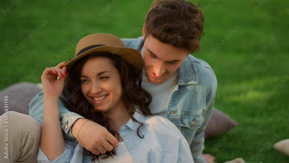 Positive girl and guy having conversation in park. Couple lying on ground Positive girl and guy having conversation in park. Couple lying on ground