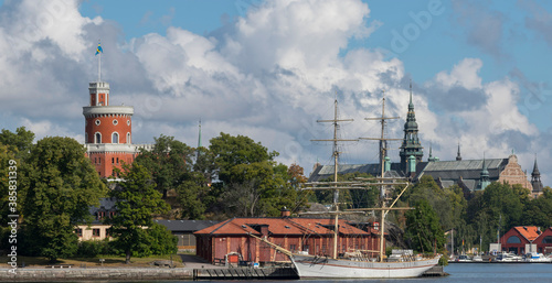 The island Skeppsholmen and the brig Tre Kronor at a quay  and a museums on the island Djurgården  behind a sunny summer day in Stockholm photo