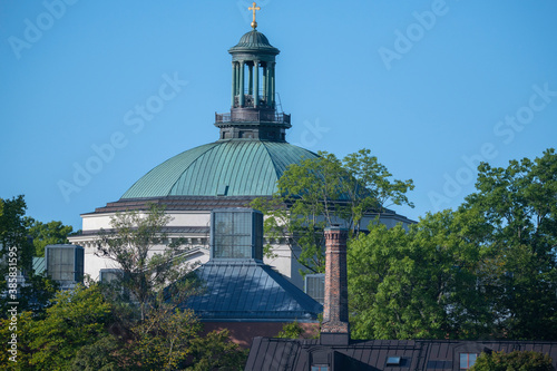 Roofs of a church and old factories in different material as cupper, tin and a brick chimney on the island Skeppsholmen in Stockholm a sunny morning