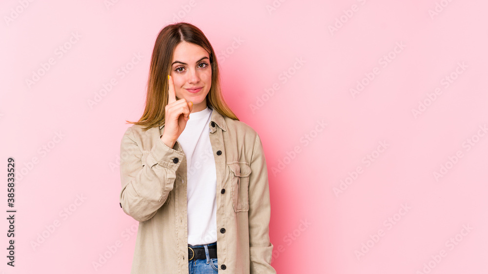Young caucasian woman isolated on pink background showing number one with finger. Young caucasian woman isolated on pink background showing number one with finger.