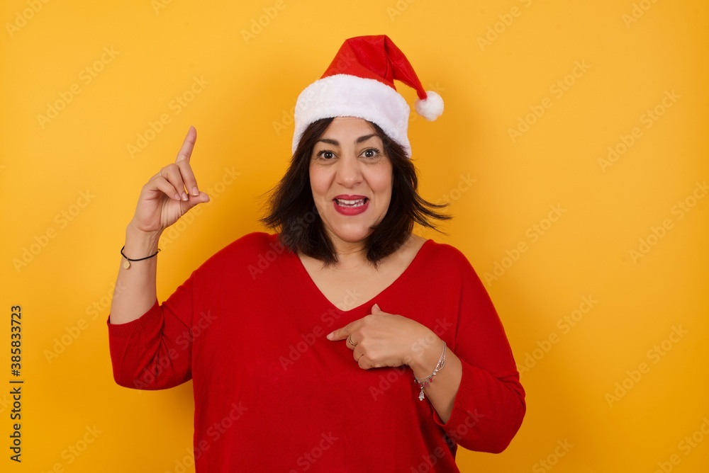 Positive glad female says: wow how exciting it is, has amazed expression, indicates something. One hand on her chest and pointing with other hand. Positive glad female says: wow how exciting it is, has amazed expression, indicates something. One hand on her chest and pointing with other hand.