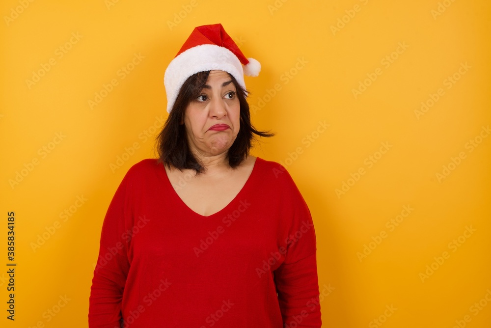 Beautiful woman with snobbish expression curving lips and raising eyebrows, looking with doubtful and skeptical expression, suspect and doubt. Standing indoors over gray background. Beautiful woman with snobbish expression curving lips and raising eyebrows, looking with doubtful and skeptical expression, suspect and doubt. Standing indoors over gray background.