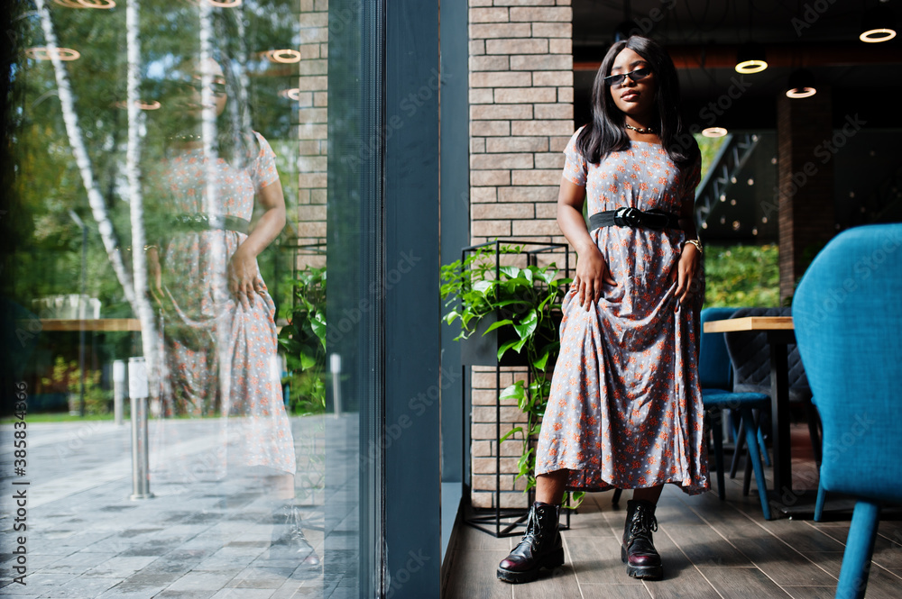 Fashion portrait of african american woman in long dress, boots and sunglasses indoor. Fashion portrait of african american woman in long dress, boots and sunglasses indoor.