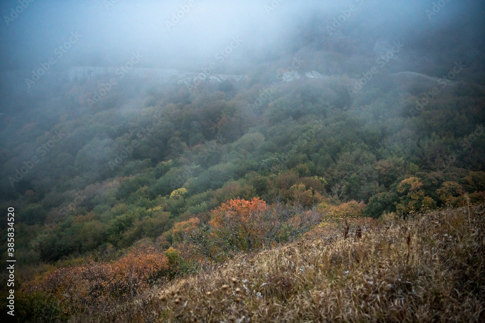 mountains at sunset in fog and gray clouds