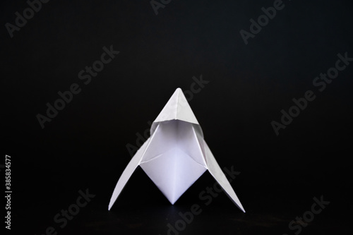 triangle of paper  elegant white origami on a black background