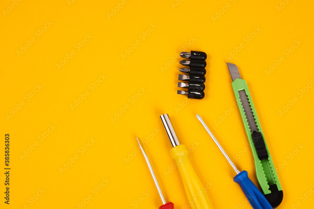 stationery knife screwdrivers and construction tools on yellow background equipment for repair industry stationery knife screwdrivers and construction tools on yellow background equipment for repair industry