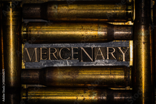 Mercenary text message on lead bar between copper 50 caliber gun casings on vintage textured grunge copper and gold background